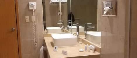 Un baño moderno con inodoro, lavabo y ducha.