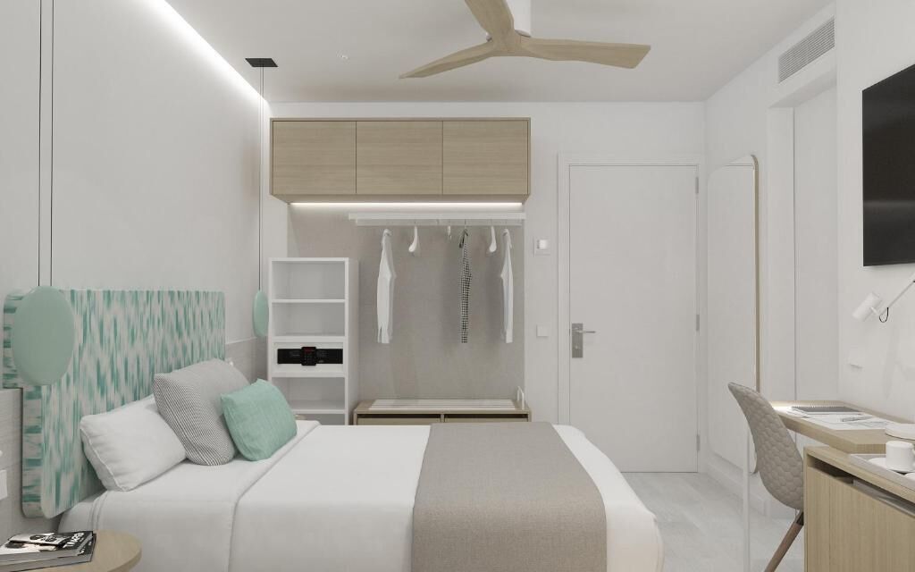 A modern bedroom with a bed, bedside table, wardrobe, and a desk with a chair.