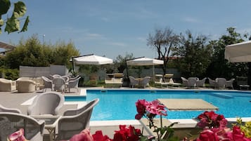 Area piscina con lettini e ombrelloni.
