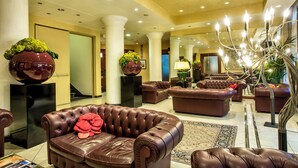 A spacious lobby with leather sofas, a large chandelier, and decorative vases. - Hotel Terme Salvarola (Sassuolo)