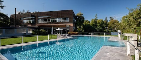 A swimming pool with a modern building in the background.