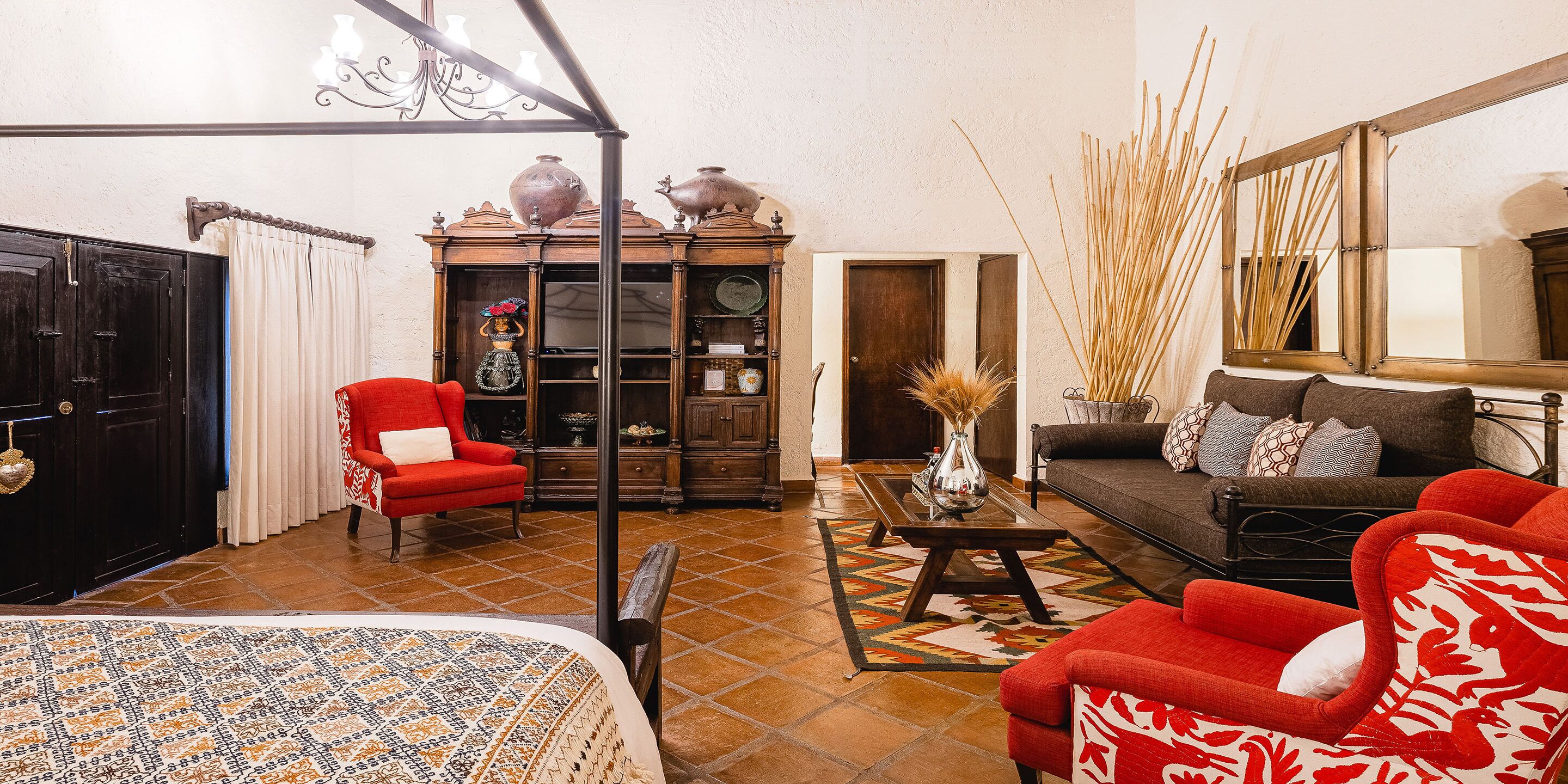 A living room with a sofa, armchairs, a coffee table, and a bookshelf.