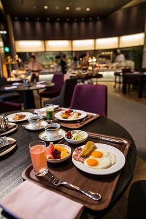 A dining table with breakfast items, including eggs, toast, and a drink, in a hotel setting. - Okayama International Hotel (Okayama)