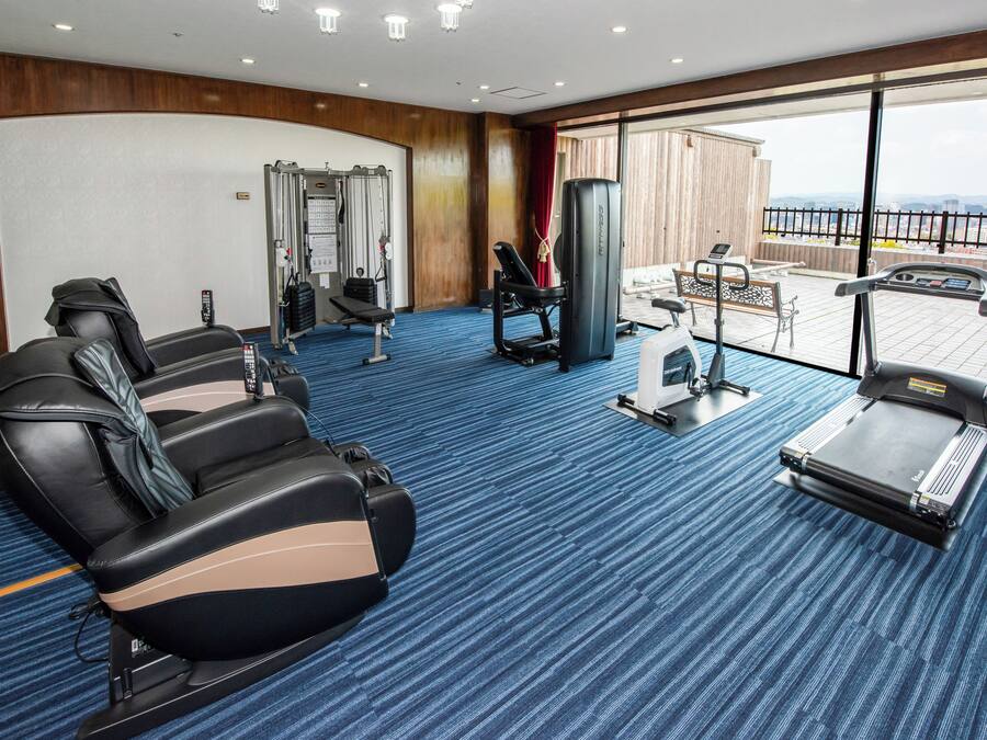 A fitness room with massage chairs, a treadmill, and exercise equipment.