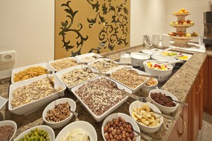 Un bufé con diversos alimentos, como cereales, nueces, frutas y verduras.