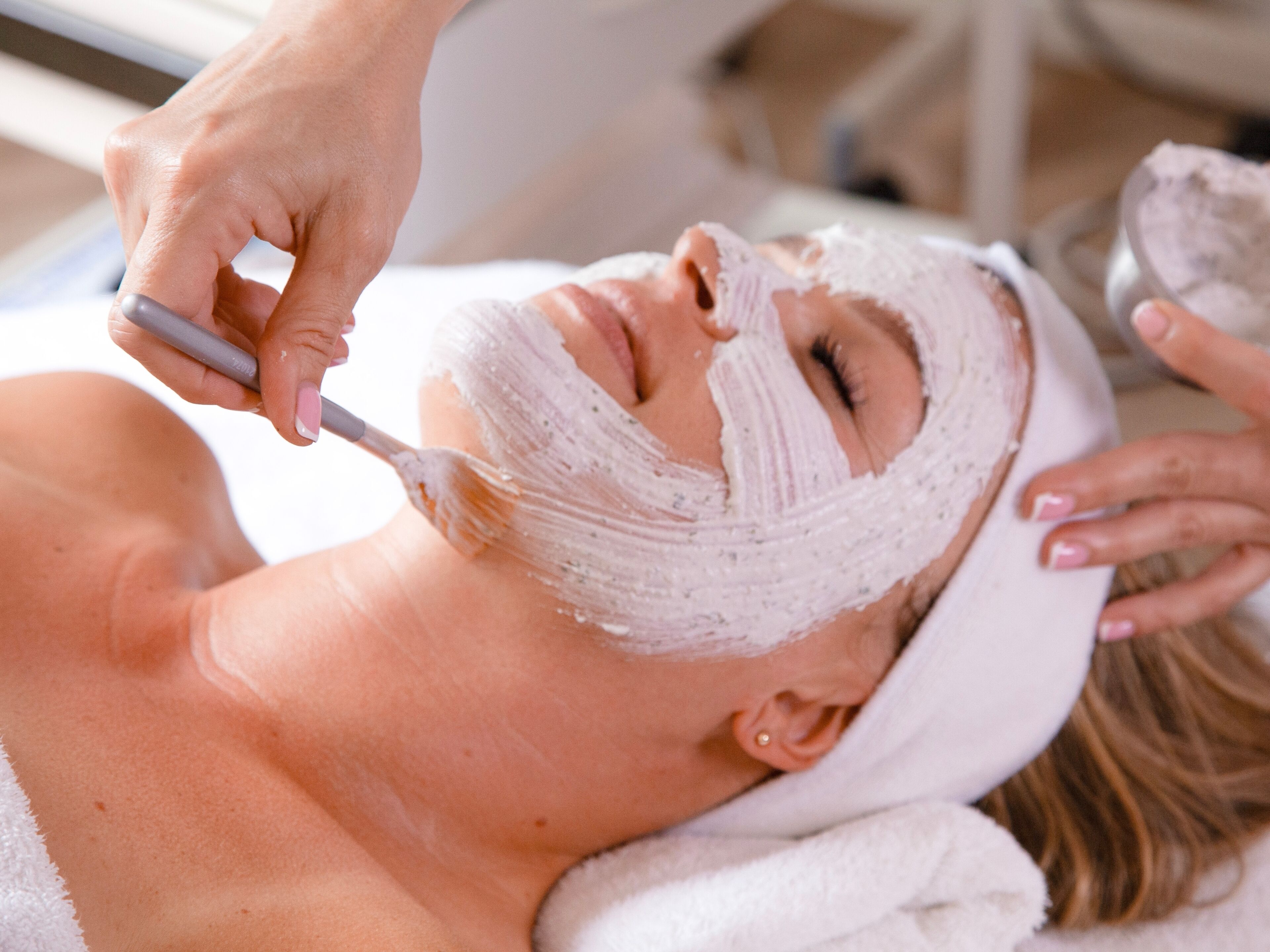 Una persona recibiendo un tratamiento facial con un cepillo.