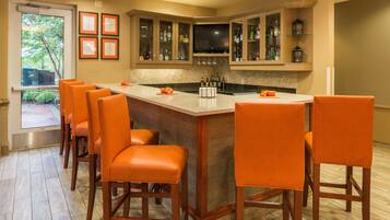 A bar area with a counter, bar stools, and a television.