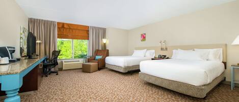 A hotel room with two beds, a desk, a chair, and a large window with curtains.