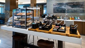 Montaje tipo bufé con diferentes platillos y una estación de café.