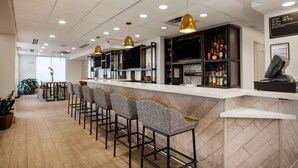A bar area with high stools, a counter, and a television.