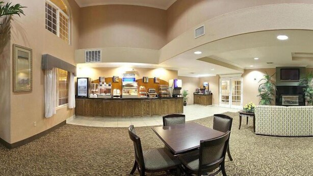 A hotel lobby with a reception desk, seating area, and a fireplace. - Holiday Inn Express Delano by IHG (Delano)