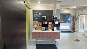 A coffee station with a sign that reads 'MUST HAVE COFFEE EXPRESS' and a counter with a coffee machine and various coffee products.