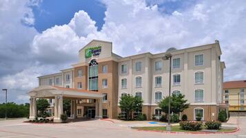 A Holiday Inn Express & Suites hotel with a covered entrance and a parking lot.
