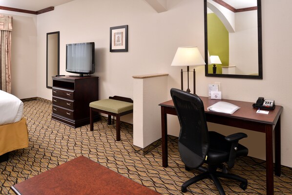 A hotel room with a bed, a desk with a chair, a television, a lamp, a telephone, and a small table with a chair. - Holiday Inn Express Hotel & Suites Sherman Highway 75 by IHG (Sherman)