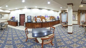 A hotel lobby with a reception desk, a coffee station, and a seating area with a patterned floor. - Holiday Inn Express Hotel & Suites Sherman Highway 75 by IHG (Sherman)