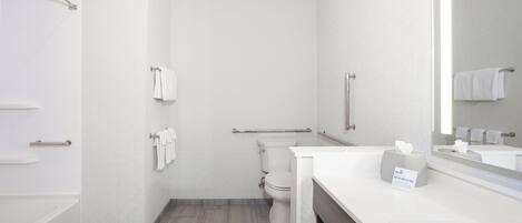 Een moderne badkamer met toilet, douche, wastafel en spiegel.
