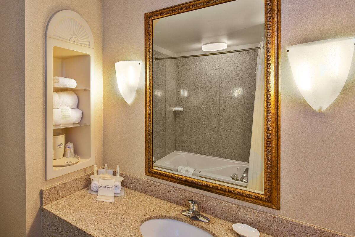 suite, 1 king bed, jetted tub (whirlpool) | bathroom | combined shower/bathtub, hair dryer, towels