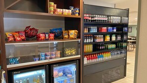 Exposição de lanches e bebidas, com diversos snacks e refrigerantes engarrafados.
