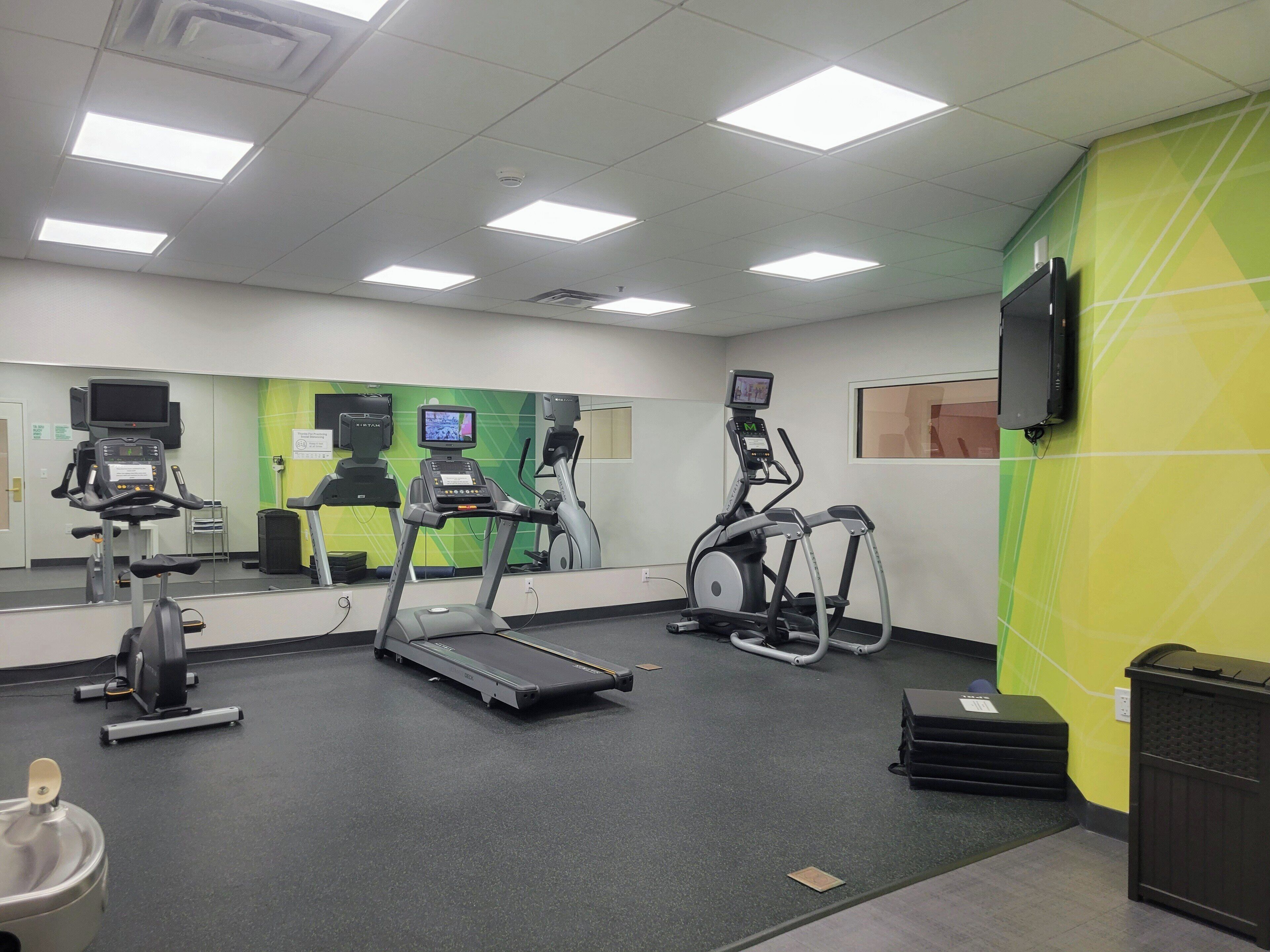 A gym with treadmills, an elliptical, and a stationary bike.