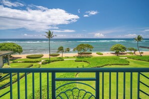 A view from a balcony overlooking a well-maintained garden with a beach and ocean in the background. - Waipouli Beach Resorts & Spa Kauai by OUTRIGGER (Kapaa)