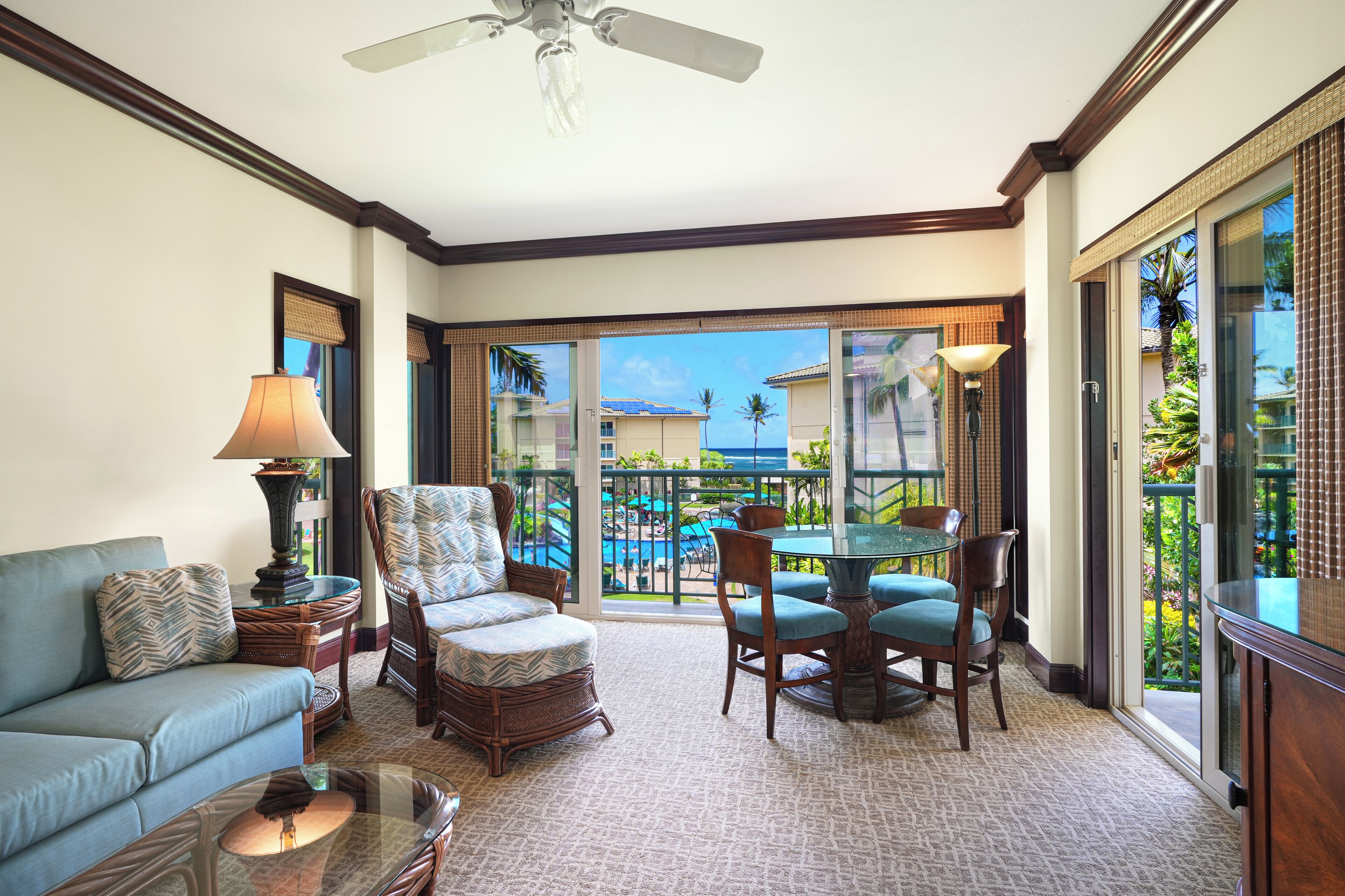 A spacious living room with a sofa, armchair, and dining table.