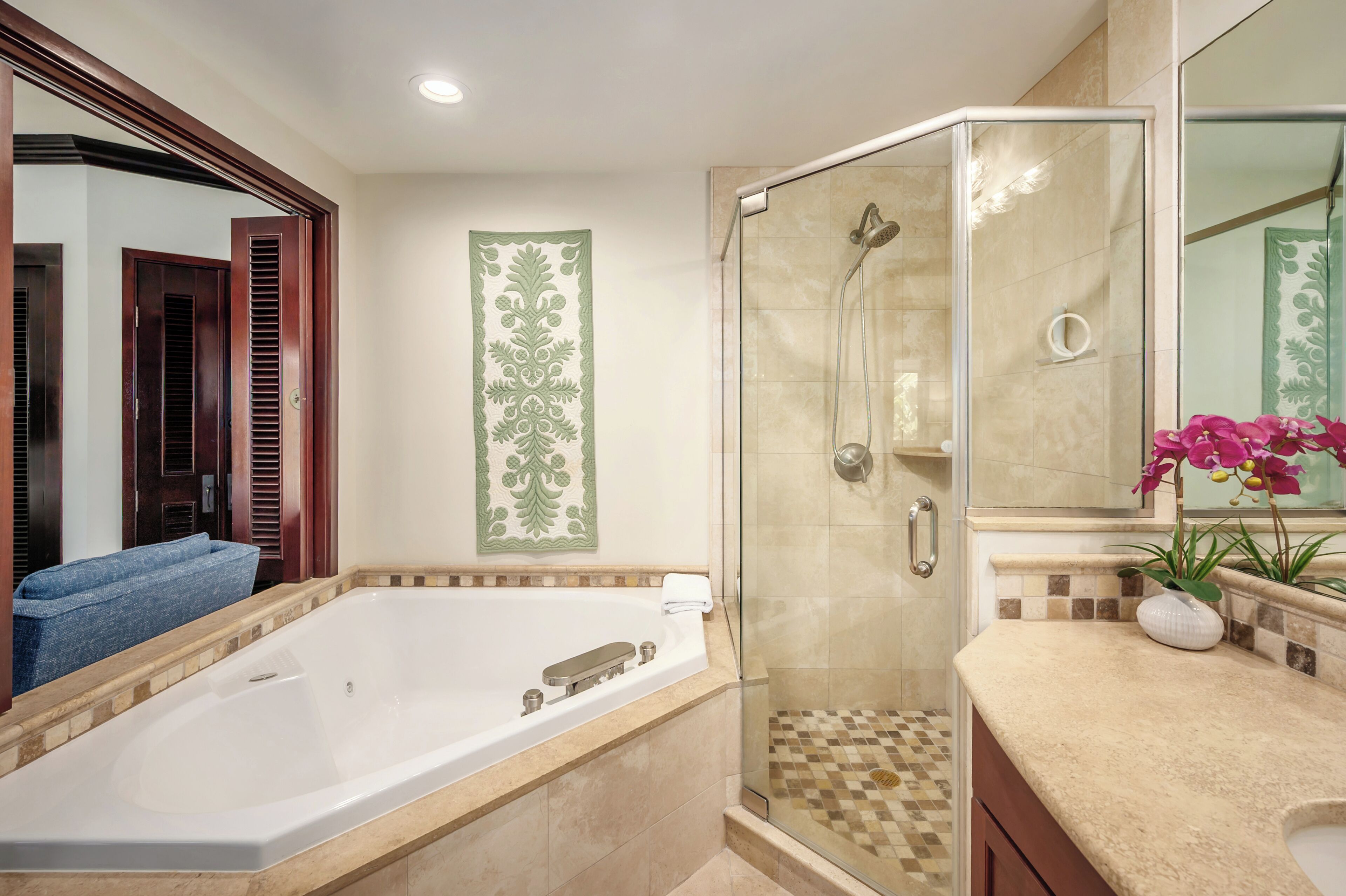 A bathroom with a bathtub, a glass-enclosed shower, and a vanity with a sink and mirror.