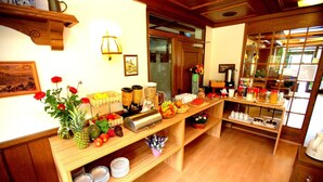 A buffet setup with various food items and condiments on a wooden table, surrounded by shelves and a window with a view. - Airport Hotel Walldorf (Moerfelden-Walldorf)