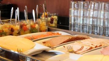 A buffet with various food items and utensils.