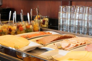 A buffet with various food items and utensils. - Bastion Hotel Apeldoorn Het Loo (Apeldoorn)