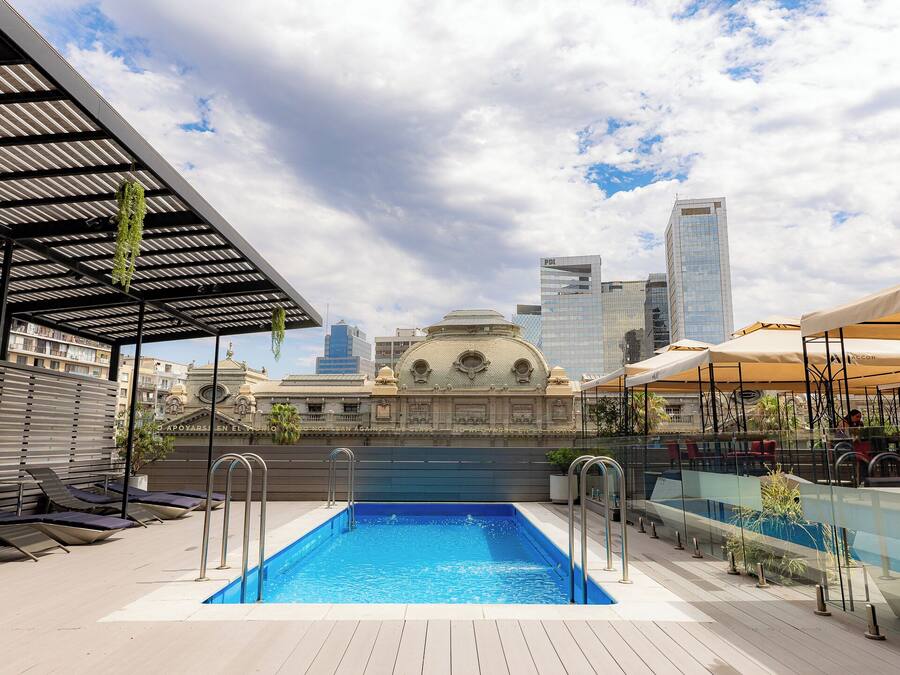 A rooftop pool with a view of a historic building and modern skyscrapers.