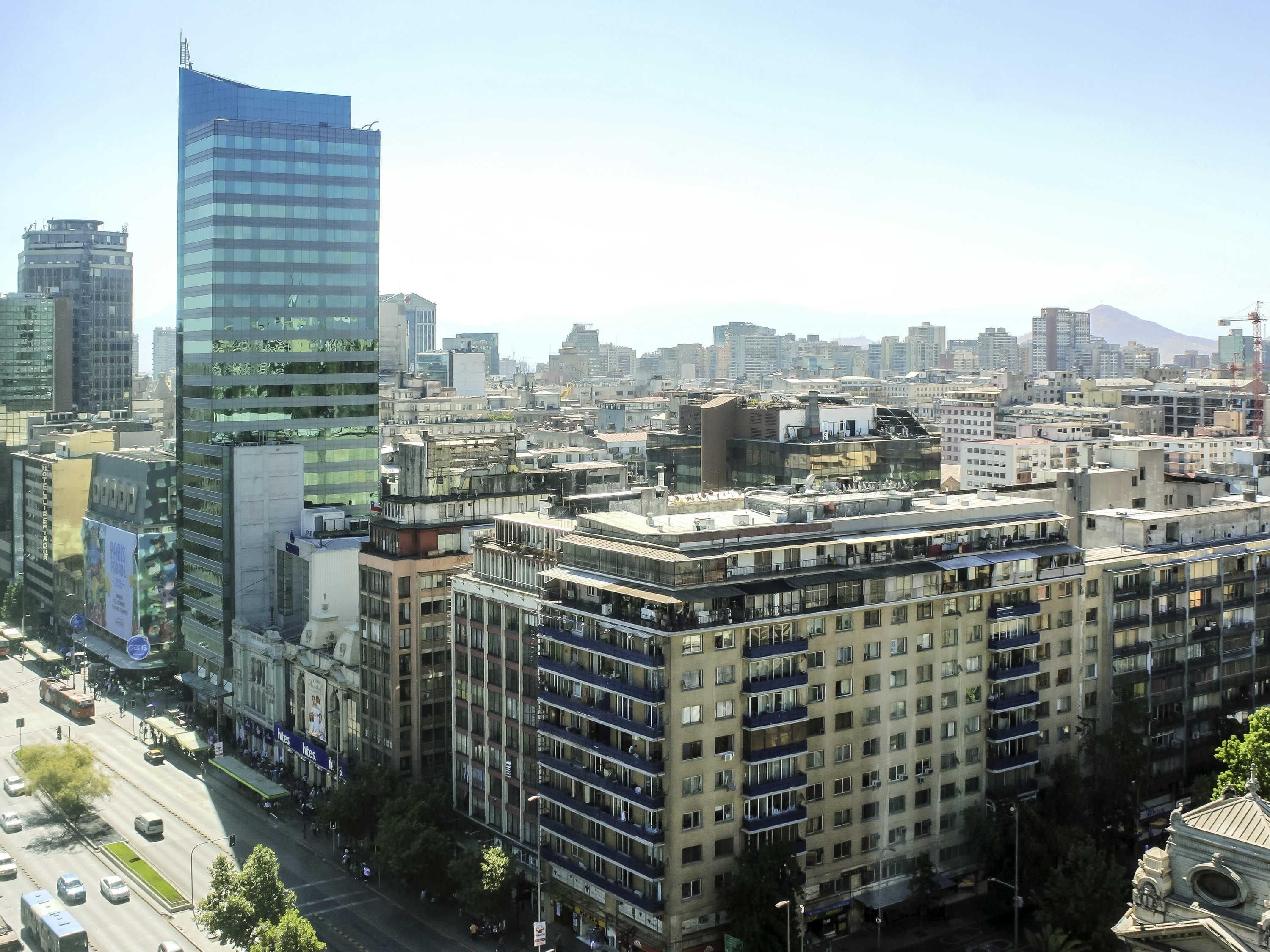 A high-rise building with a modern glass facade, surrounded by mid-rise residential buildings.