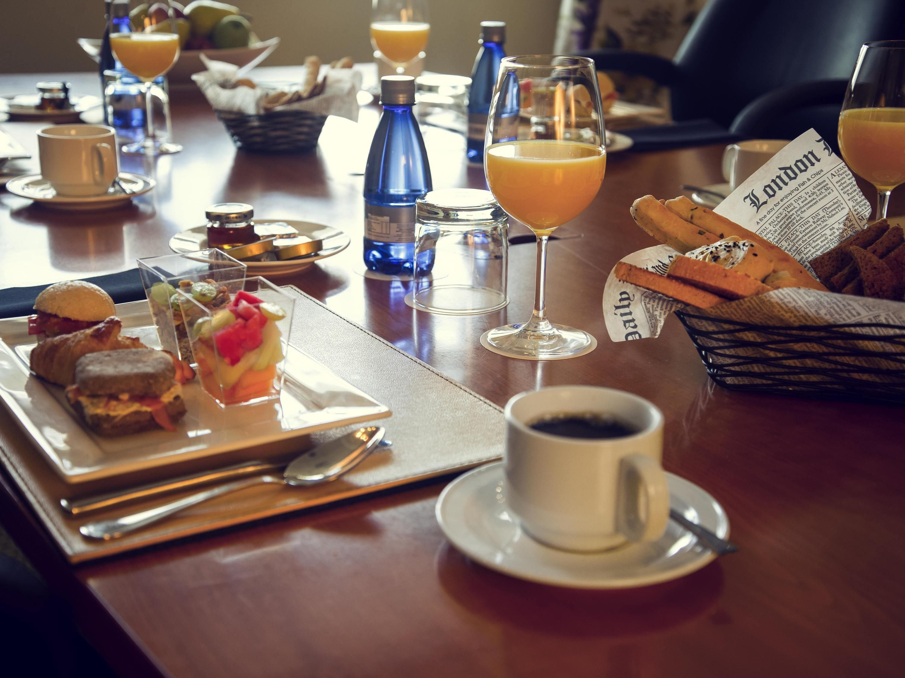 Un desayuno servido en una bandeja, una taza de café y un periódico.