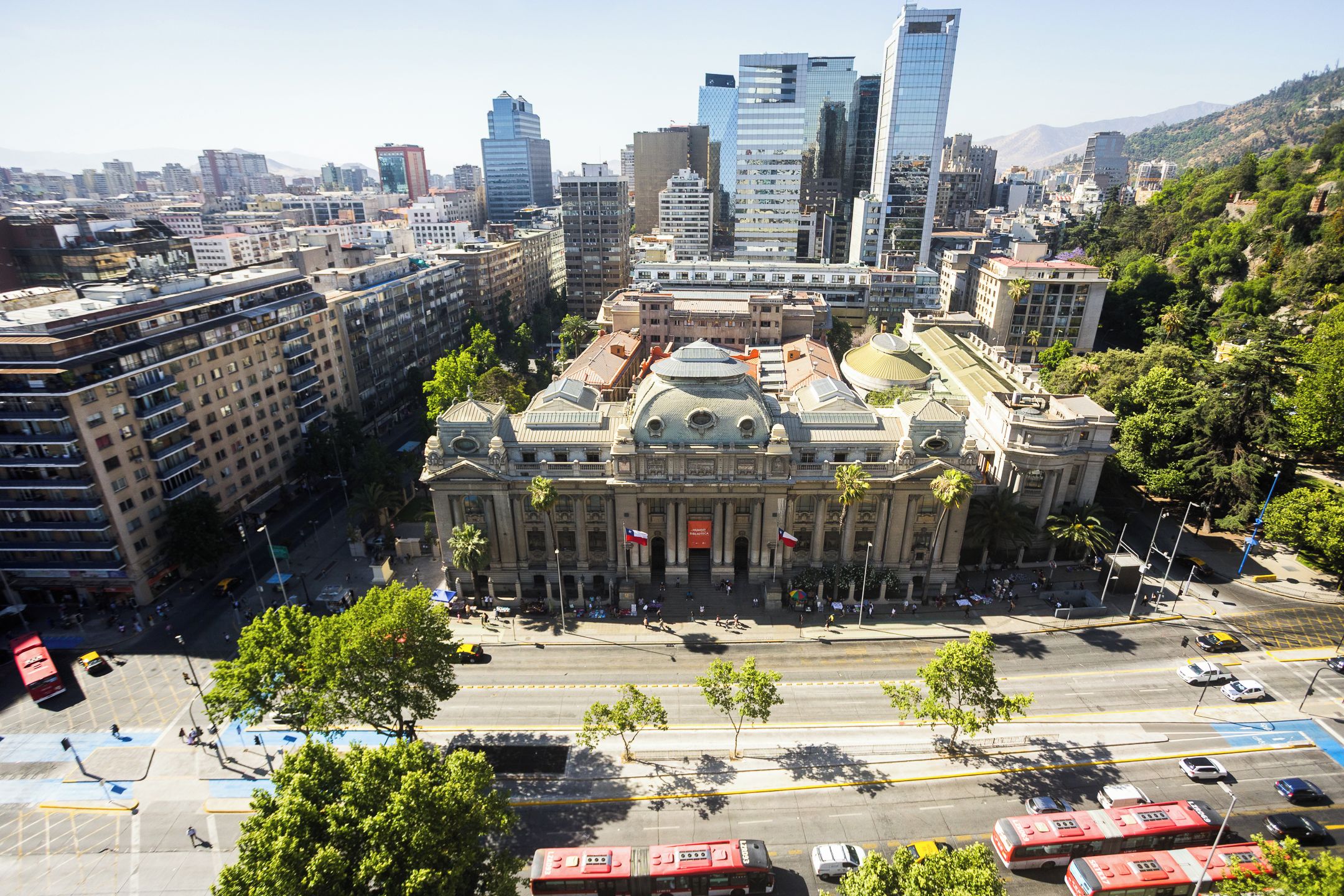 A cityscape with a prominent historical building surrounded by modern skyscrapers.