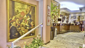 A lobby with a large classical painting, a reception desk, and a marble floor. - Hotel Mec (Milan)