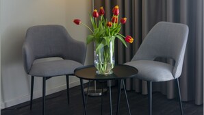 Una habitación moderna con dos sillones grises, una mesita redonda y una lámpara de pie.