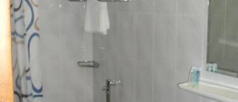 A bathroom with a toilet, sink, and shower curtain.