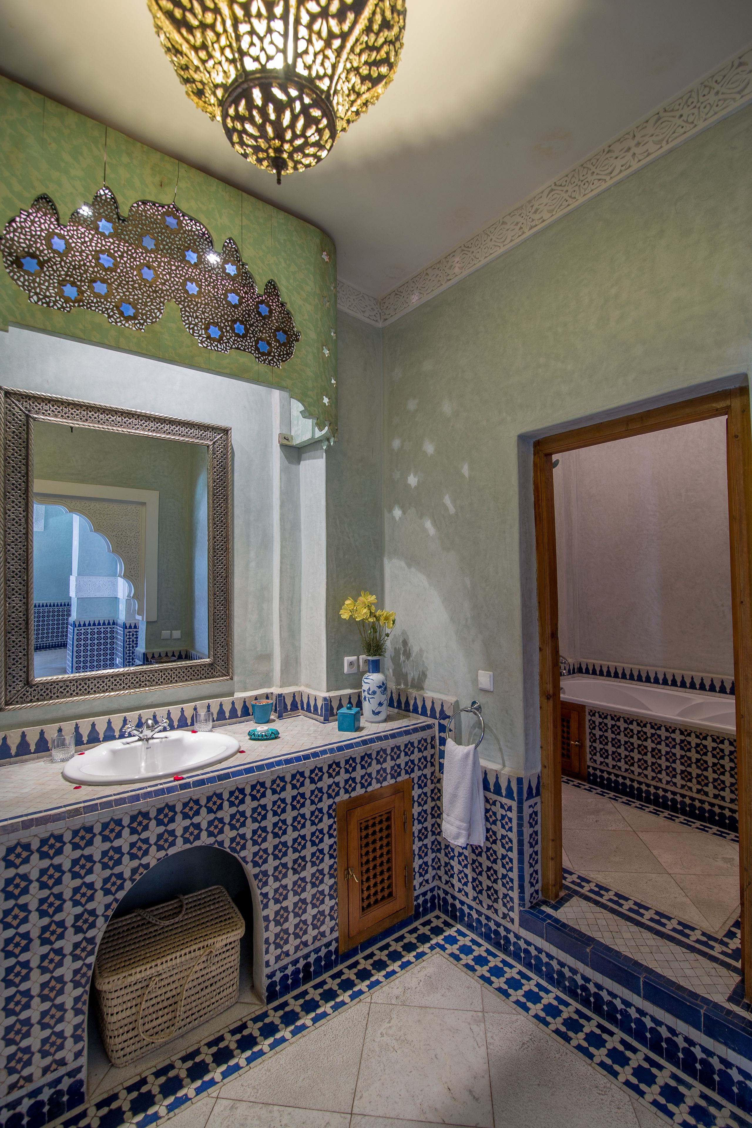 Un baño con un espejo grande, un lavamanos y una pared decorativa.