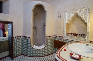 Un baño con bañera, lavabo y azulejos decorativos.