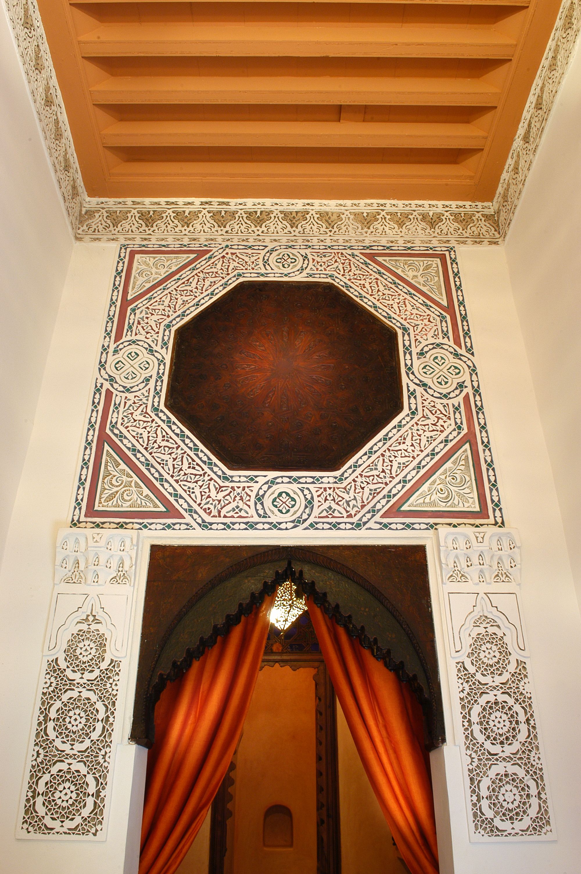 Un techo ornamentado con detalles intrincados en azulejos y un tragaluz octogonal grande.