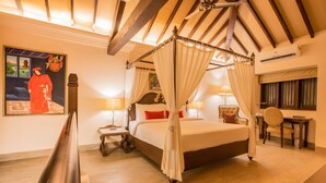 Une chambre à coucher avec un lit à baldaquin, un bureau avec une chaise et une table de chevet avec une lampe.