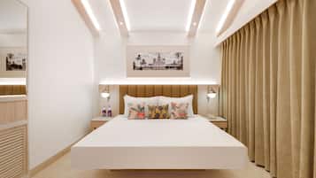 Un dormitorio moderno con una cama grande, lámparas de noche, un cuadro enmarcado sobre la cama y un ventanal con cortinas.