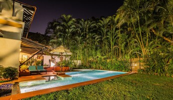 Una piscina al aire libre, sombrillas, sillones reclinables de piscina