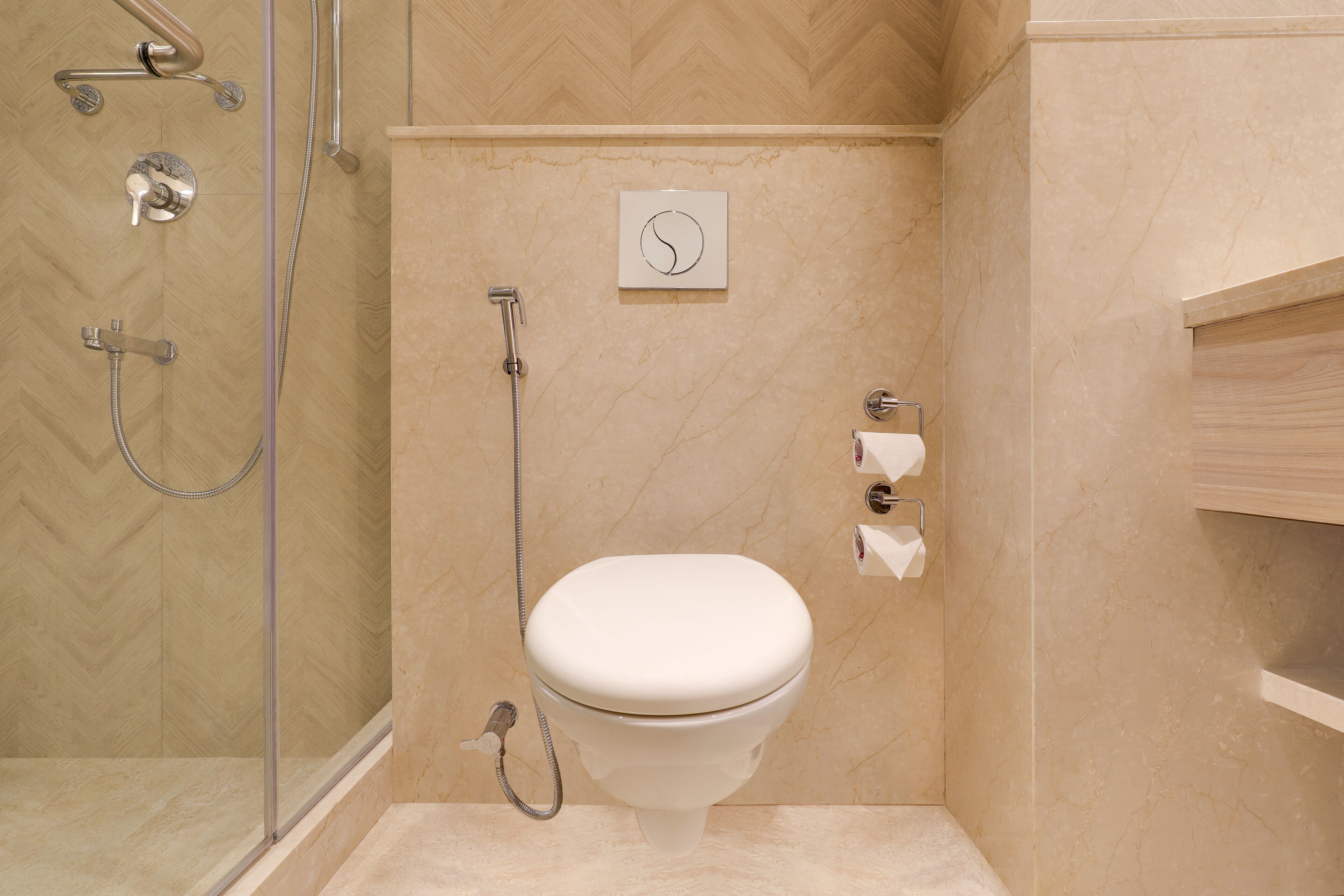 Un baño con inodoro, ducha y perchero para toallas.