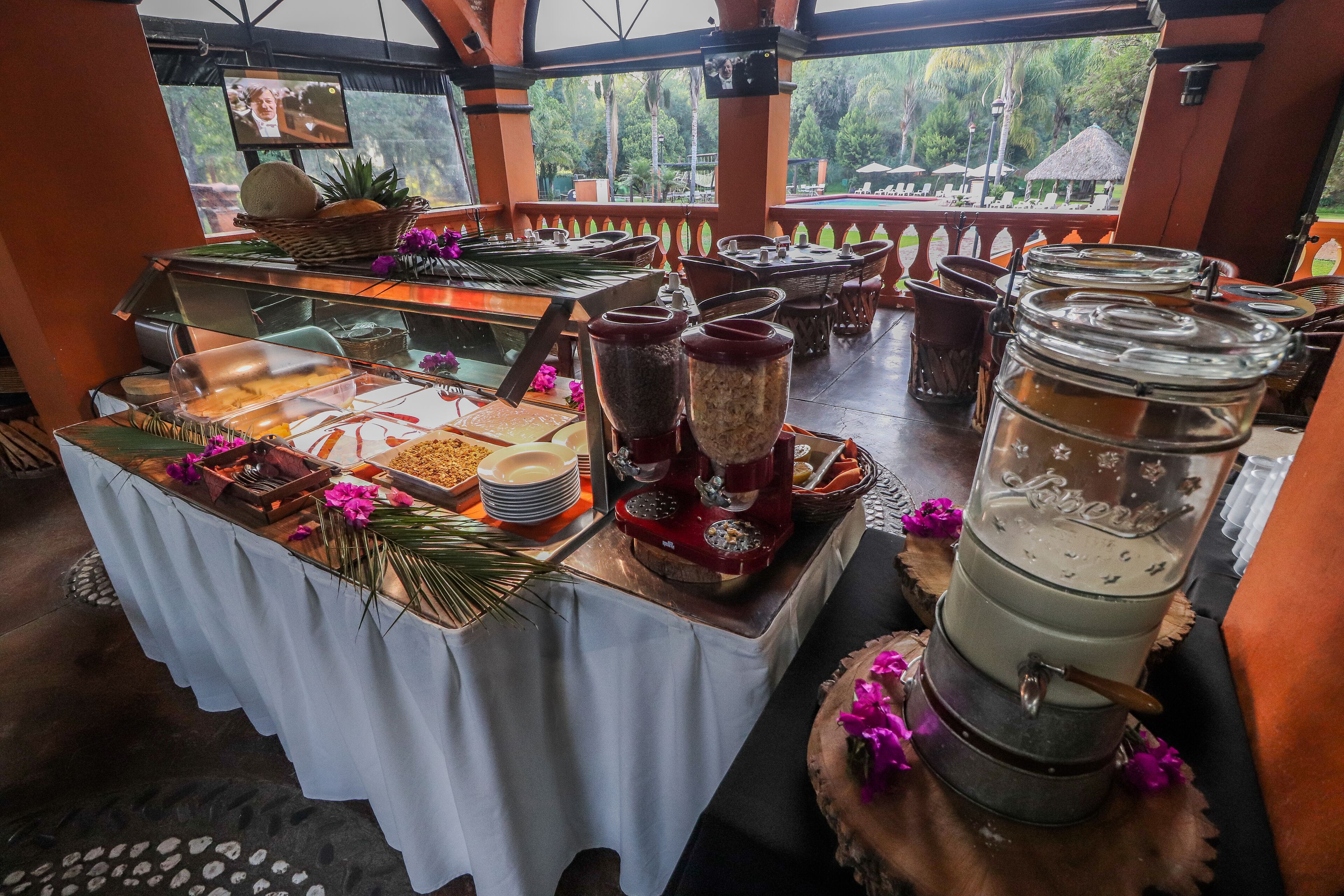 Un buffet proposant une variété de plats et d’accompagnements, un écran de télévision et une vue sur l’extérieur.