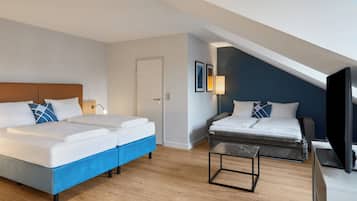 Ett hotellrum med två sängar, en TV, ett skrivbord och en dörr.