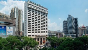 A modern hotel with a grid-like facade, surrounded by other buildings and greenery. - GreenTree Inn Guangdong Shenzhen Dongmen Business Hotel (Shenzhen)