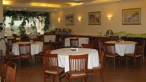 A restaurant with round tables and wooden chairs, featuring a warm interior and wall-mounted lighting. - GreenTree Inn Guangdong Shenzhen Dongmen Business Hotel (Shenzhen)