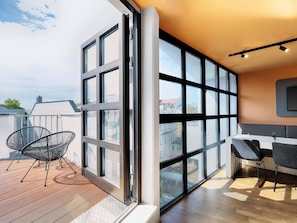 Eine moderne Wohnung mit großen Fenstern, einer Holterrasse und einem Essbereich.