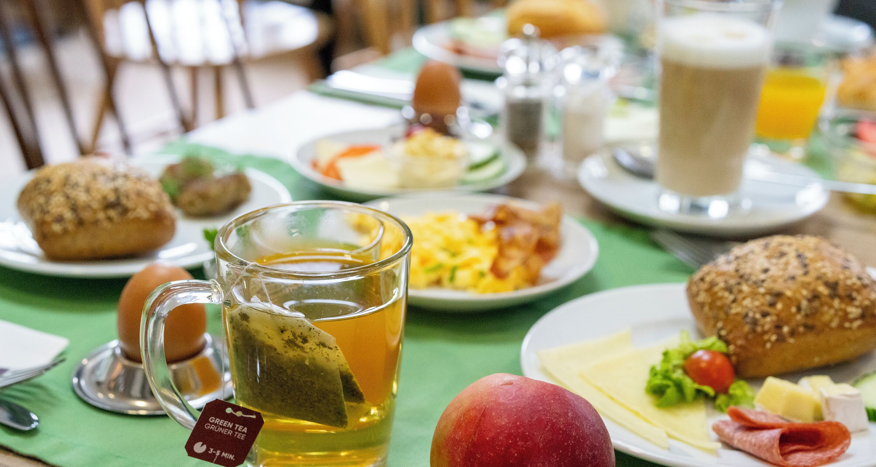 Un desayuno con diferentes platillos, una taza de té y un muffin.