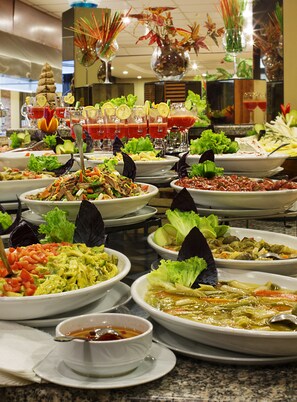 Een buffet met diverse gerechten, waaronder salades, soepen en een selectie drankjes.